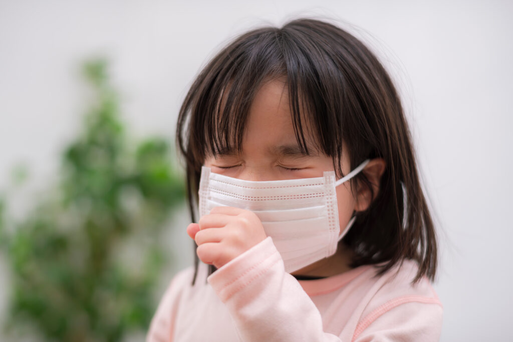子供がマスクをして咳をしている様子